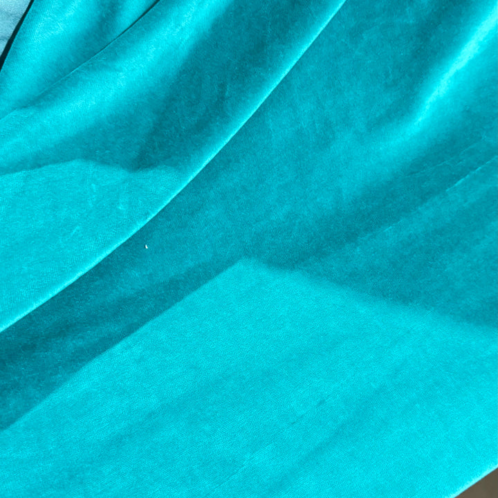 Close-up of teal fabric with folds