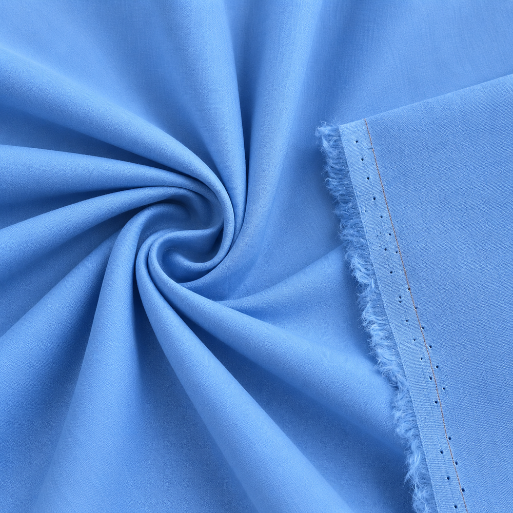 Close-up of cotton stretch poplin fabric in baby blue color, showcasing its smooth texture and lightweight design.