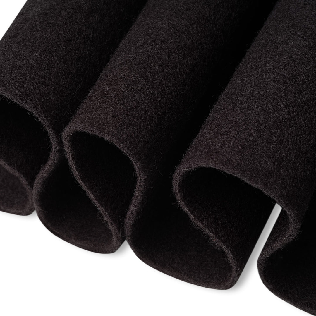 Close-up of black felt rolls on a white background