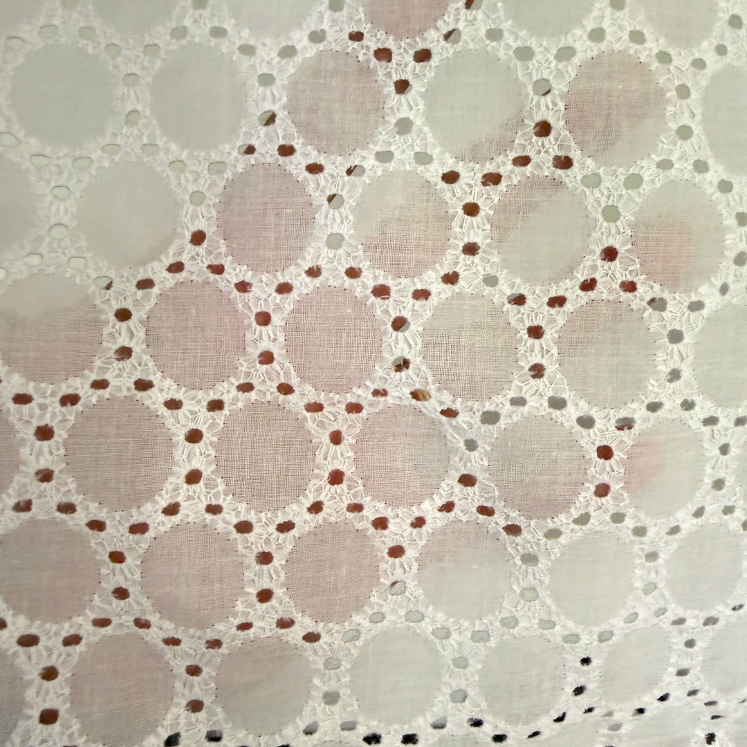 Close-up of a textured fabric with circular patterns and small dots.