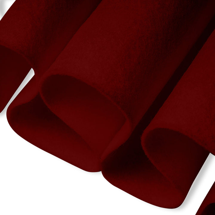 Close-up of dark red fabric with folds on a white background