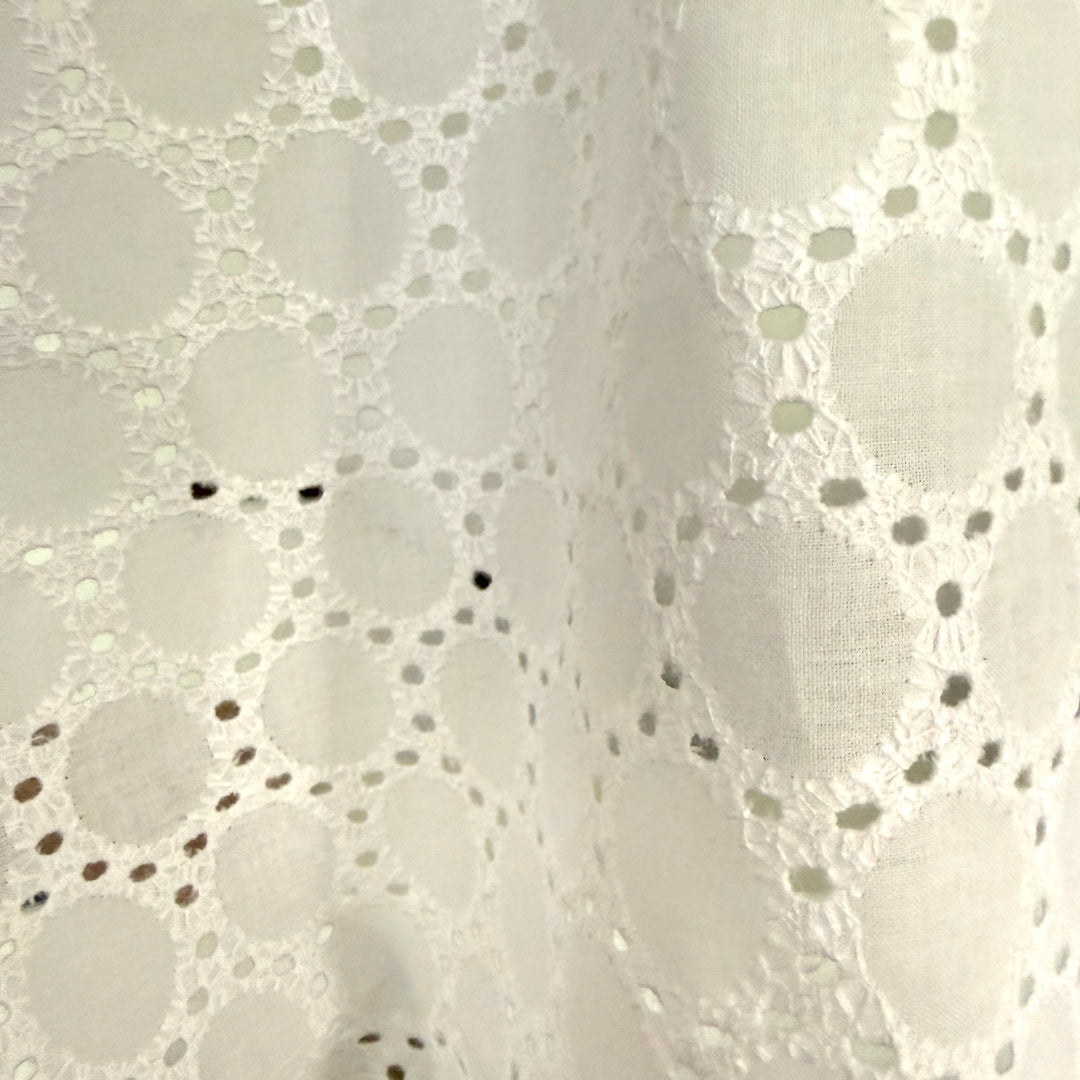 Close-up of a white lace fabric with a subtle pattern