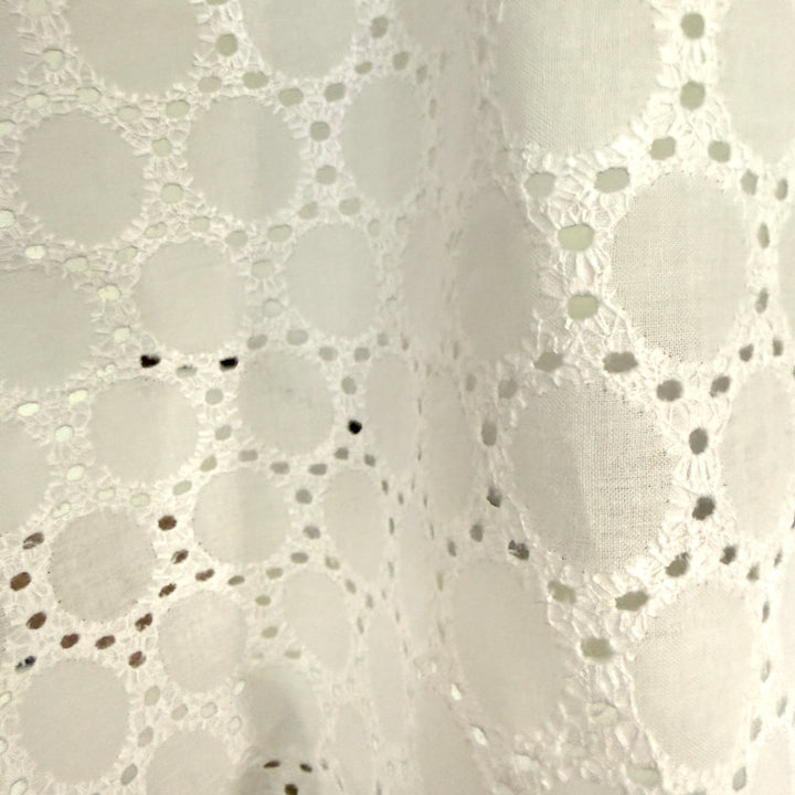 Close-up of a white lace fabric with a subtle pattern