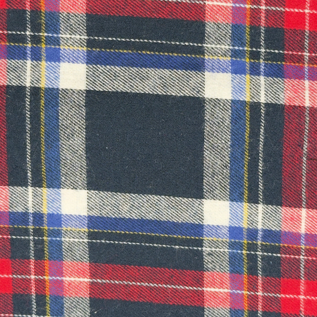Close-up of a plaid fabric with red, blue, and black patterns.