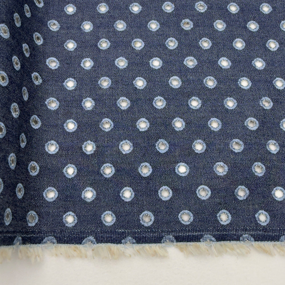 Navy blue fabric with small white polka dots on a white background