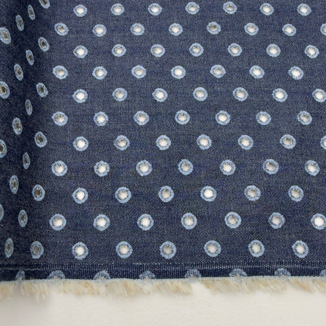 Navy blue fabric with small white polka dots on a white background