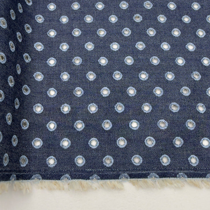 Navy blue fabric with small white polka dots on a white background