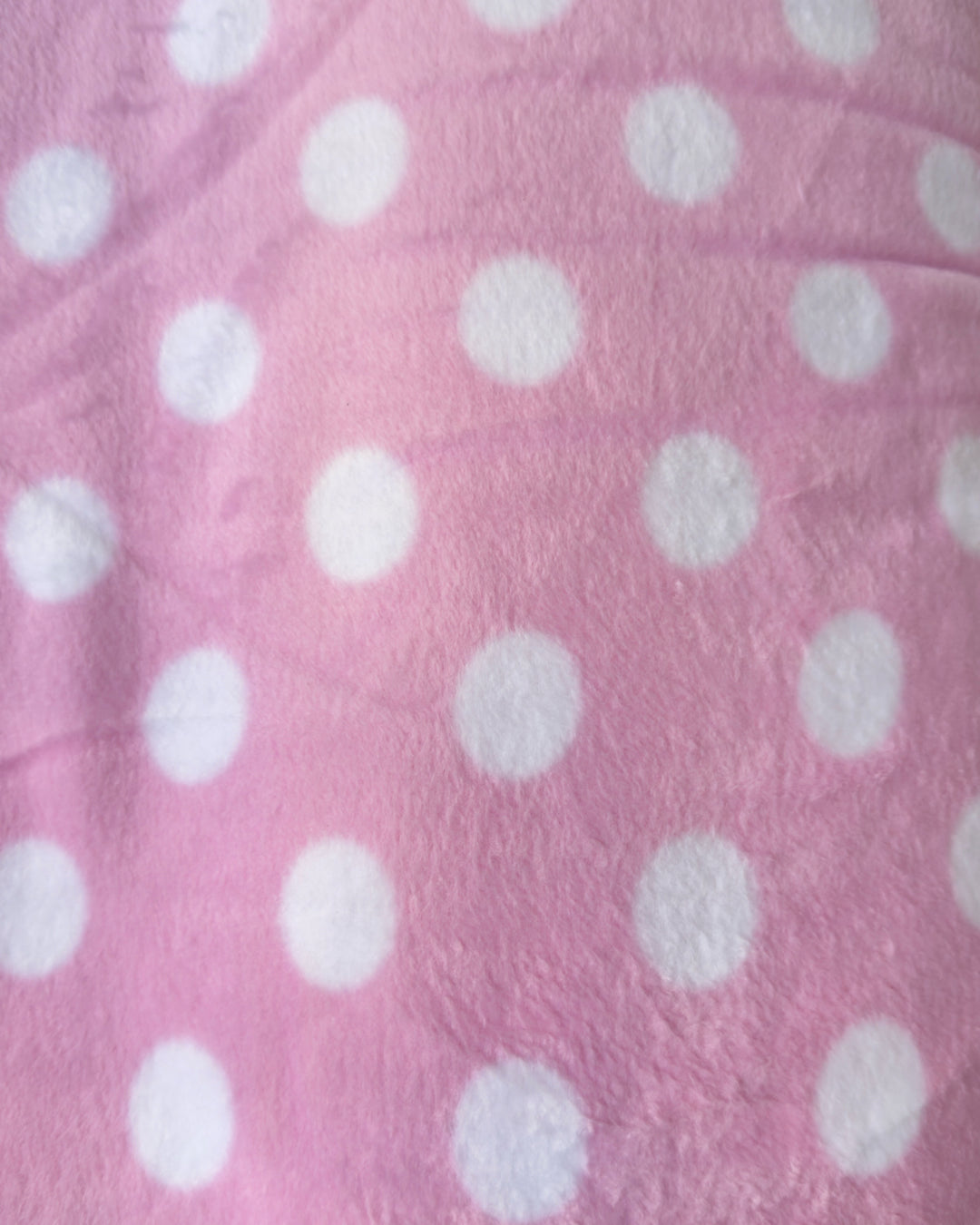 Close-up of pink fabric with white polka dots