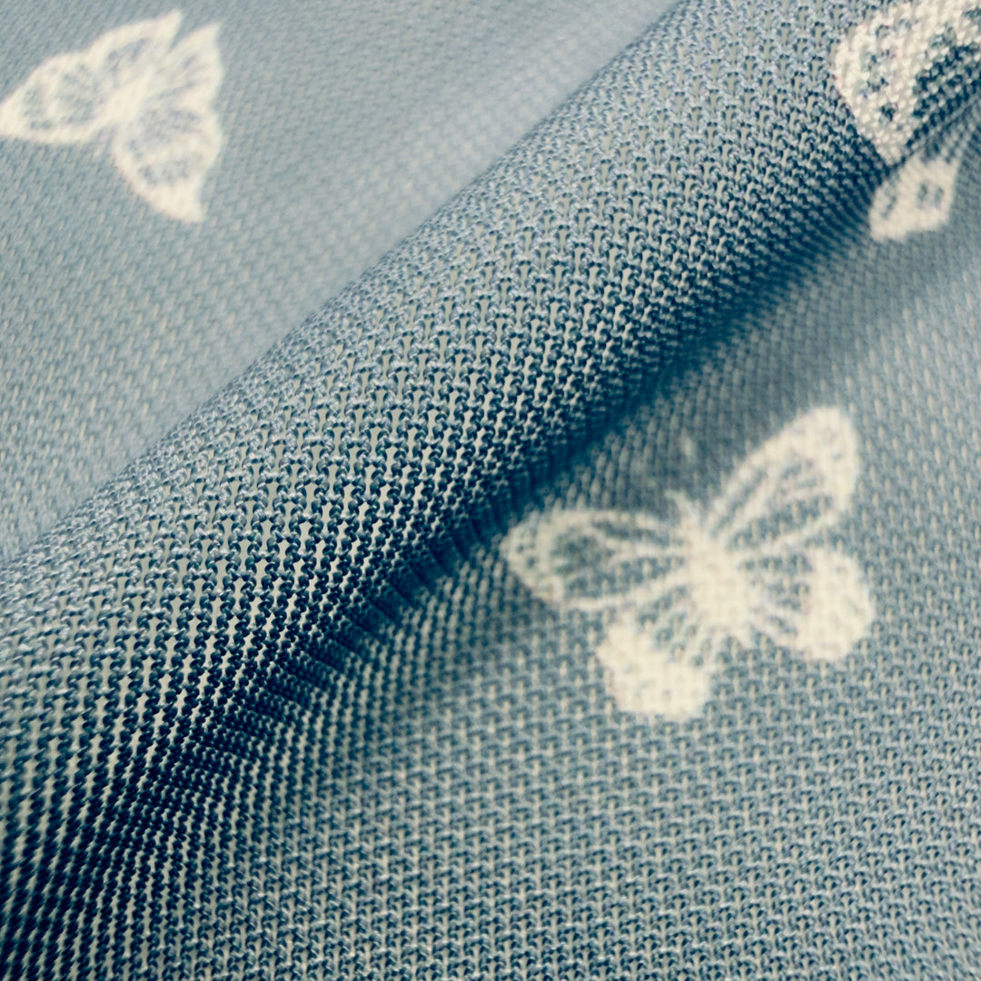 Close-up of chambray butterfly nylon spandex fabric showcasing its texture and design, ideal for stylish garments.