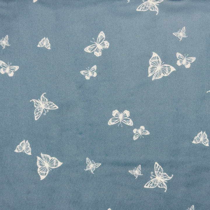 Nylon spandex fabric design featuring white butterflies on a blue background, perfect for stylish garments.