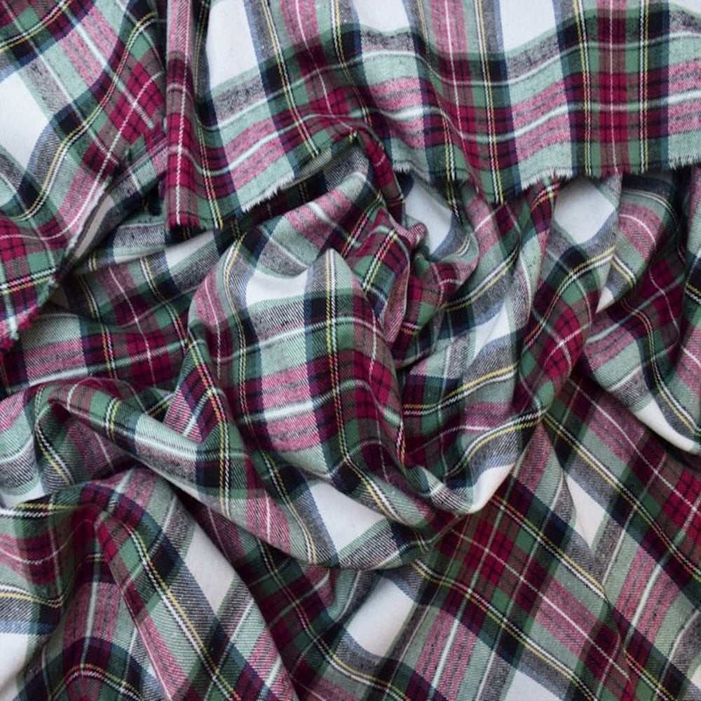 Close-up of cotton flannel plaid fabric with red, green, and white colors.